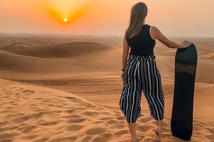 Experience the magic of the Arabian Desert at sunset with endless golden dunes inviting exploration and the anticipation of an unforgettable adventure on a camel rock safari.